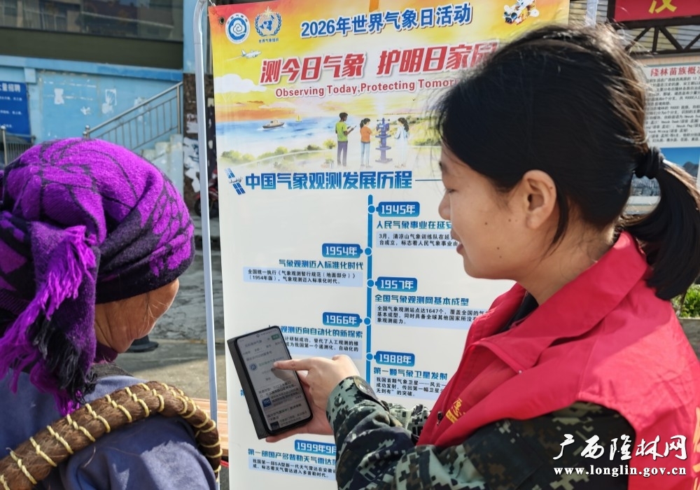 隆林各族自治县气象局气象科普宣传员田盼盼同志正在给少数民族群众介绍“五彩隆林气象”微信公众号如何使用