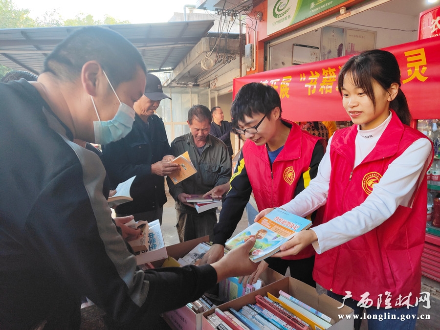 图为桠杈镇新时代文明实践志愿者赠书给群众