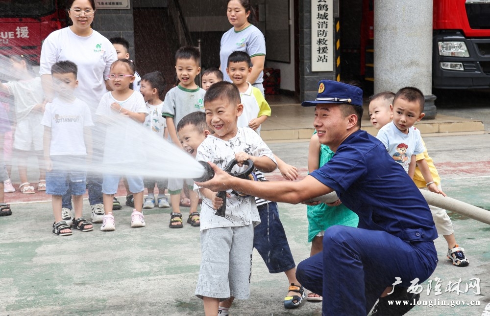 小朋友们在消防员的指导下体验水枪灭火 (2)