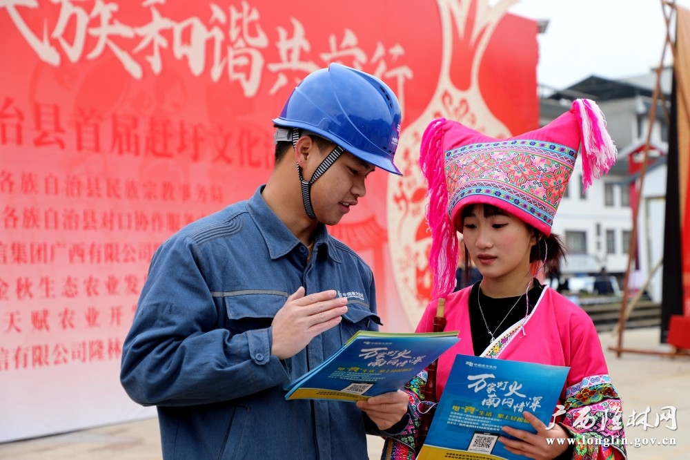 近日，在隆林各族自治县首届赶圩文化活动，“五彩民族班”成员现场作安全用电宣传。1王亚玲  摄