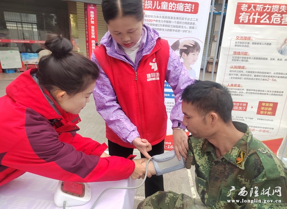 图为隆林各族自治县残联志愿者为群众量血压