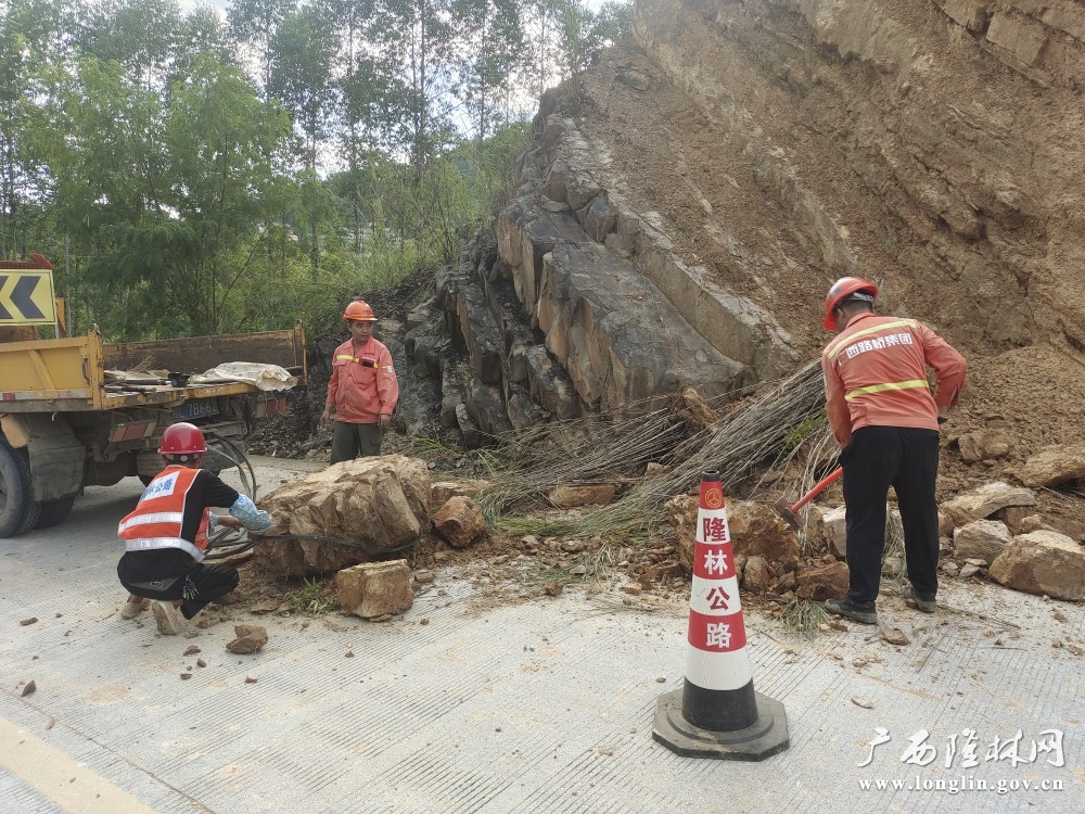 养护人员正在清理边坡滑塌的泥土、树枝等杂物，让道路畅通。周龙英摄